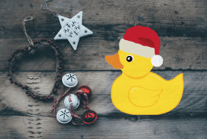 Natural looking Christmas background with plastic duck in a Christmas hat