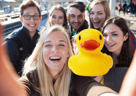 Group of young people and a yellow plastic duck doing a selfie