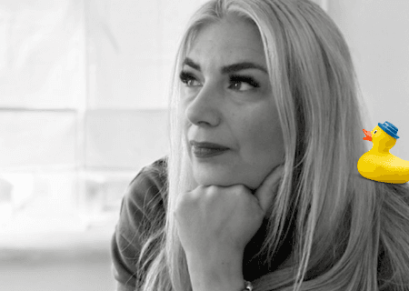 Picture of blonde lady with plastic duck on her shoulder